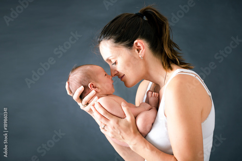 Fotografia Young mother, kissing and hugging her newborn baby boy