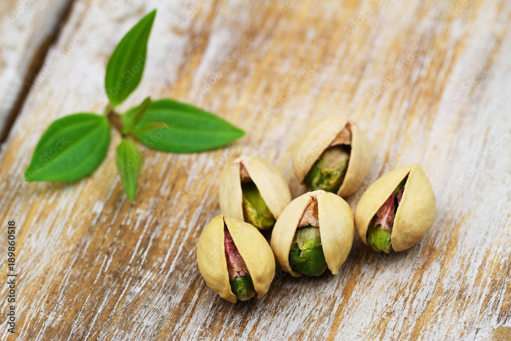 Five pistachio nuts on rustic wooden surface
Five pistachio nuts on rustic wooden surface