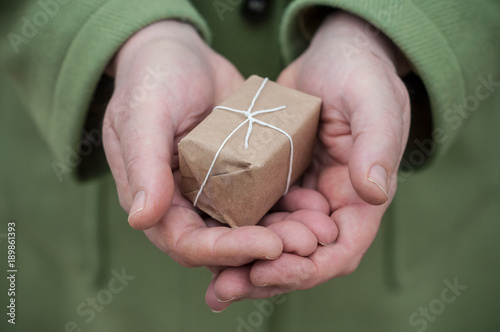 détail main de femme offrant un cadeau 