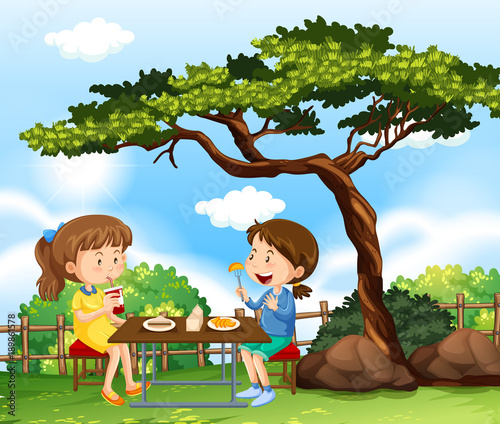 Two girls having picnic in park