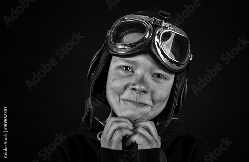 young pilot in goggles on a black background photo