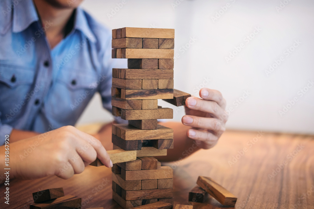 Images of hand of businesspeople placing and pulling wood block on the tower, Alternative risk concept, plan and strategy in business, Risk To Make Business Growth Concept With Wooden Blocks Images of hand of businesspeople placing and pulling wood block on the tower, Alternative risk concept, plan and strategy in business, Risk To Make Business Growth Concept With Wooden Blocks