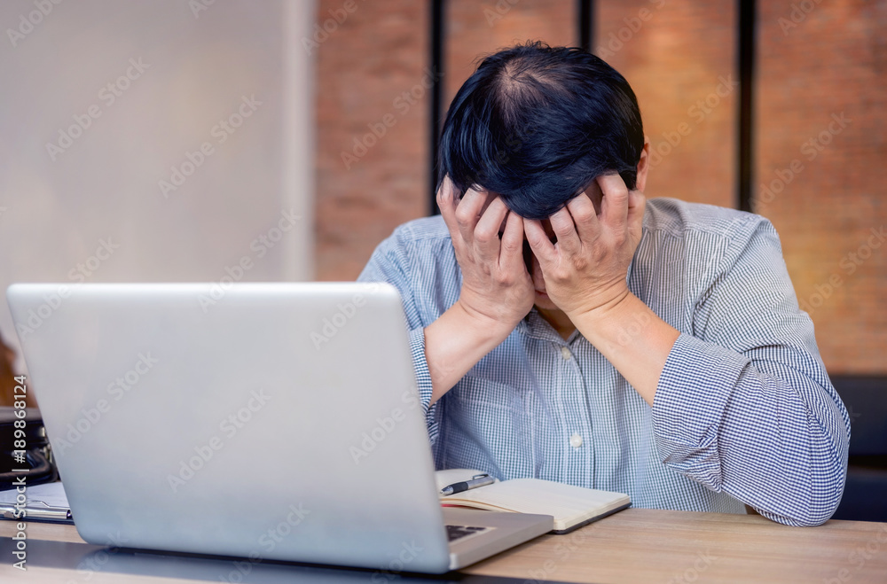 Image of Frustrated stressed business man and graph business with computer laptop in the workplace