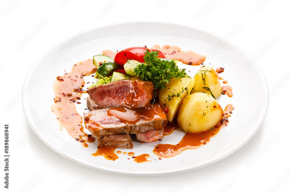Grilled steak with vegetables on white background Grilled steak with vegetables on white background