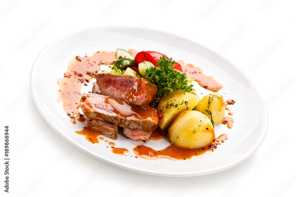 Grilled steak with vegetables on white background Grilled steak with vegetables on white background