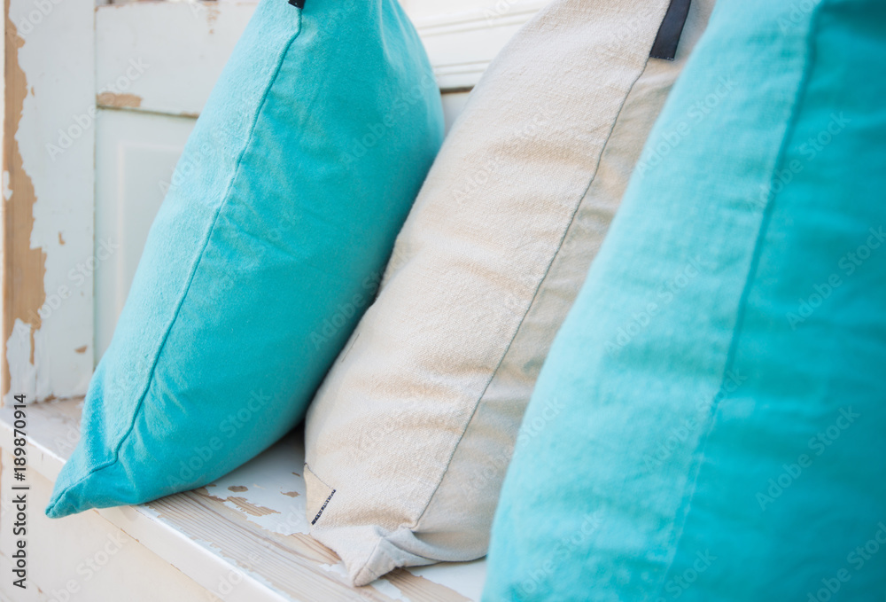 Colourful pillows on white wooden bench