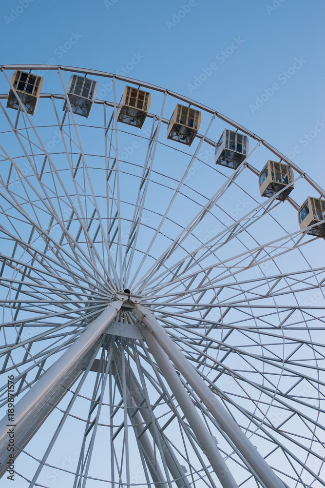 Fototapeta premium Ferris wheel on cloudy sky background
