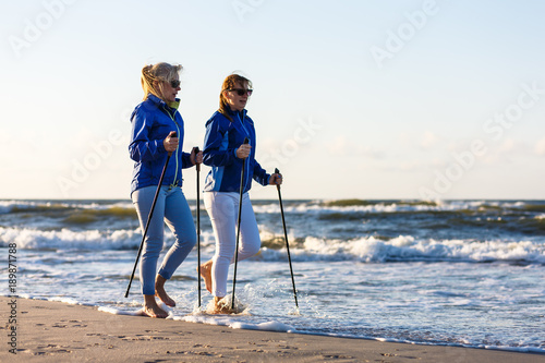 Nordic walking - active people working on beach