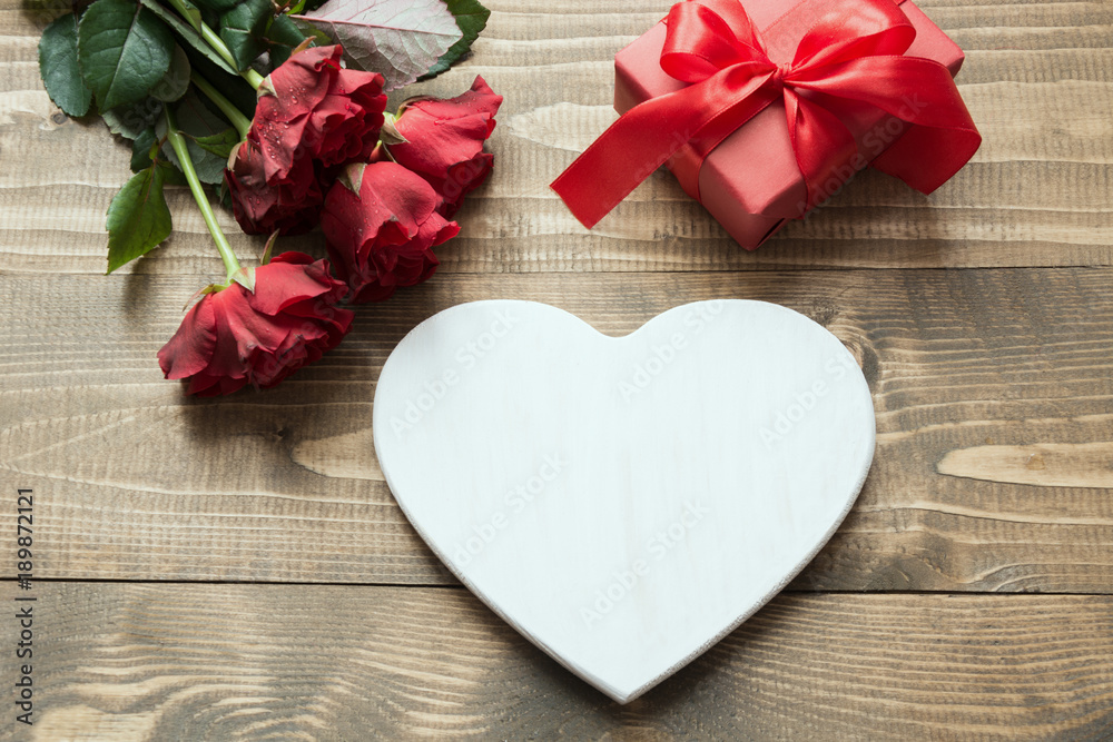 Valentines day greeting card with bouquet red rose flowers, heart as blank and gift box on wooden table. Copy space. Top view. Valentines day greeting card with bouquet red rose flowers, heart as blank and gift box on wooden table. Copy space. Top view.
