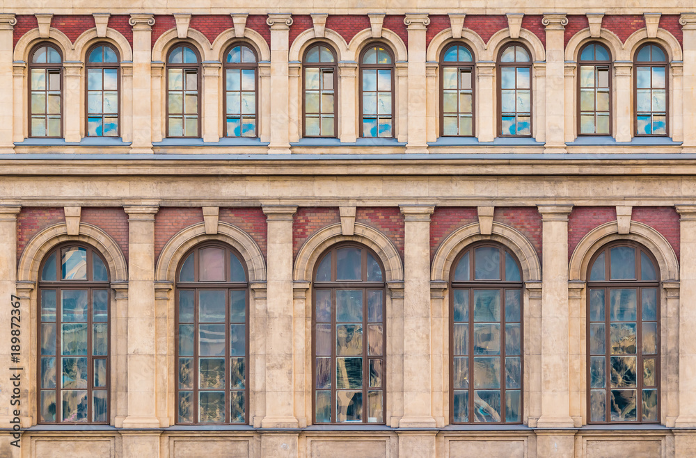 Many windows in a row on the facade of the urban historic building front view, Saint Petersburg, Russia
