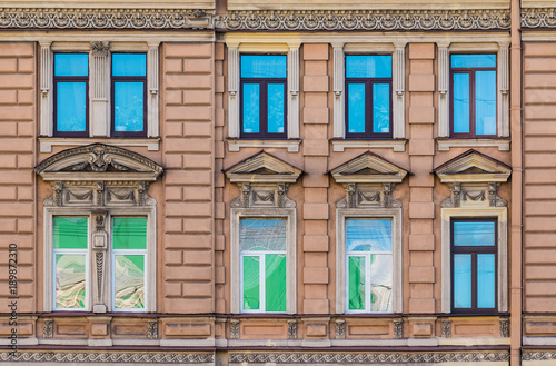 Several windows in a row on the facade of the urban historic building front view, Saint Petersburg, Russia 