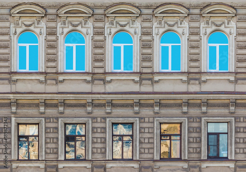Several windows in a row on the facade of the urban historic building front view, Saint Petersburg, Russia 