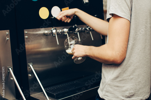 in the bar, a barman picks up a light beer in a glass. party at the bar. low alcohol beverages