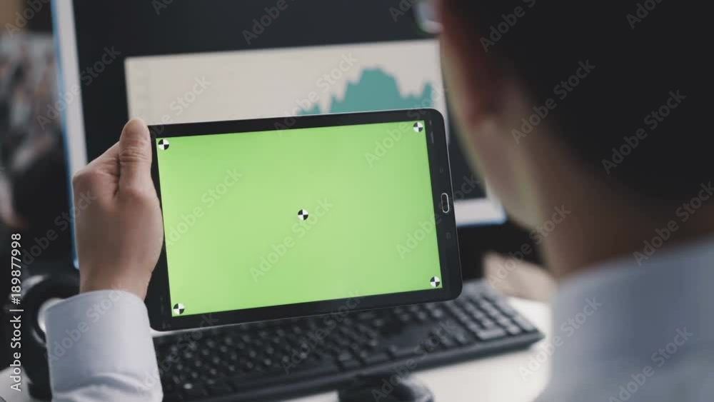 A man using a tablet PC with a green screen in front of camera. 4K
