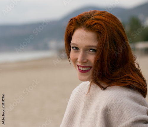 Obraz na plátně A nice  girl with a beautiful smile is sitting on the beach