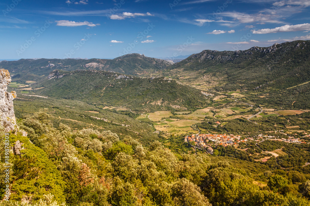 A small French town in a valley surrounded by mountains. Top view.