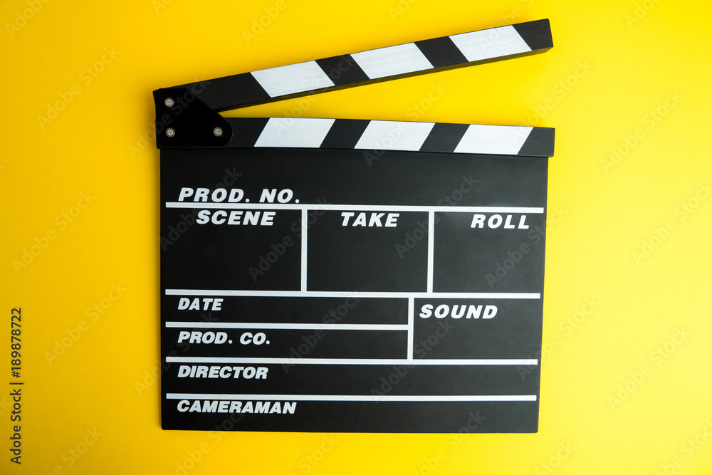 Cinema minimal concept. Watching film in the cinema. clapper board on yellow background. Screenwrite desktop