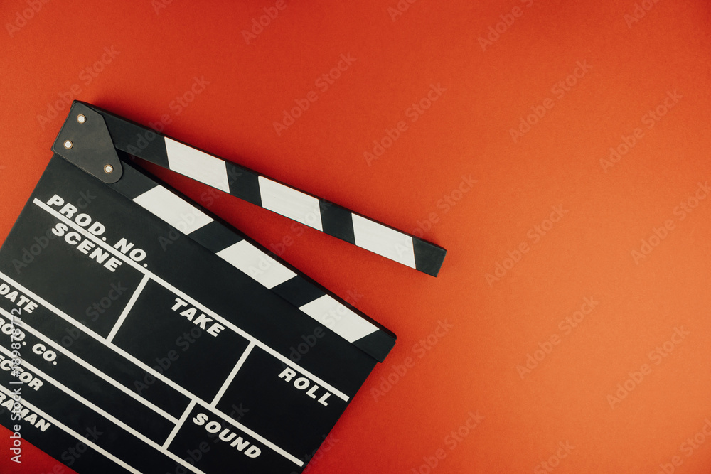 Naklejka premium Cinema minimal concept. Watching film in the cinema. clapper board on red background. Screenwrite desktop