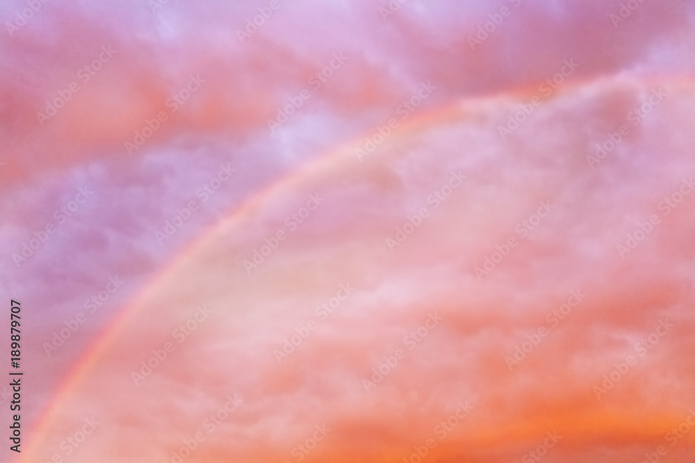 Rainbow in the orange sky. Sunset. Orange, yellow and violet clouds. Rainbow after rain.
