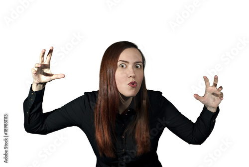 girl on a white background frightens the viewer, taking a menacing pose and making a terrible face..