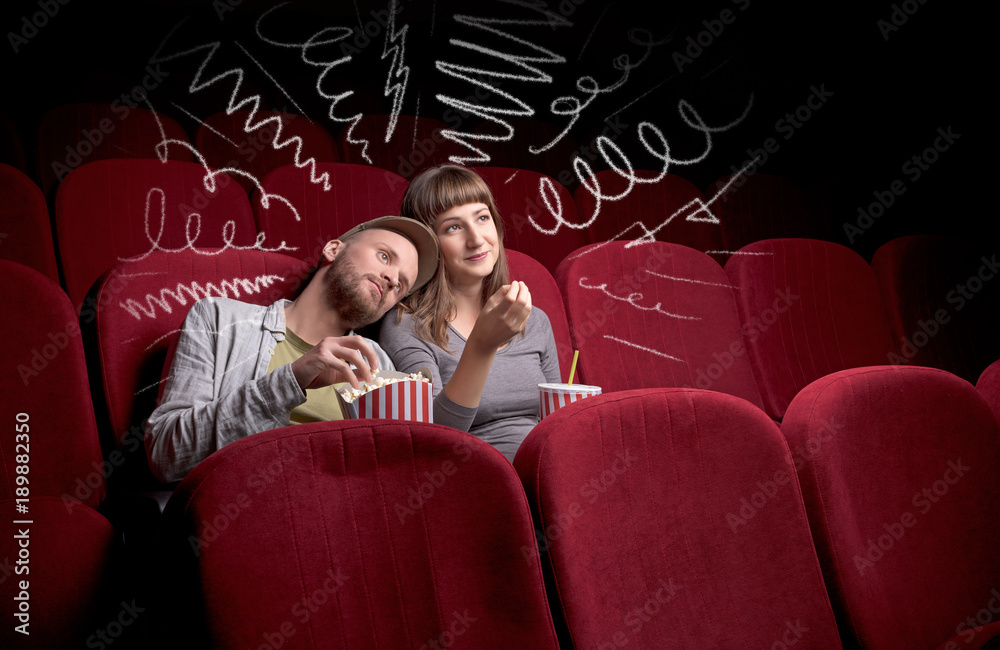 Naklejka premium Cute couple in cinema watching movie