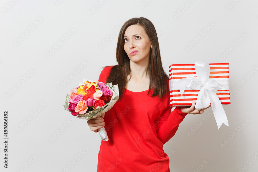 Sad upset woman in red clothes holding bouquet of beautiful roses flowers, present box with gift isolated on white background. St. Valentine's Day, International Women's Day birthday holiday concept. Sad upset woman in red clothes holding bouquet of beautiful roses flowers, present box with gift isolated on white background. St. Valentine's Day, International Women's Day birthday holiday concept.