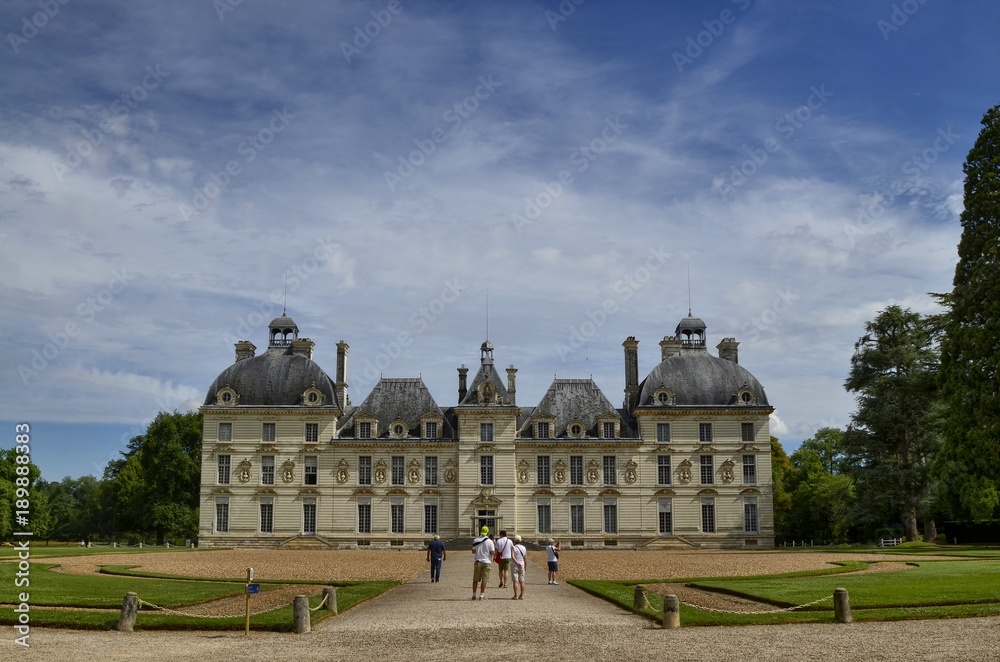 Cheverny, Loire Valley, France. 26 June 2017 at 12:00. View of three quarters to the left of the facade, present some visiting tourists, blue sky with white clouds.