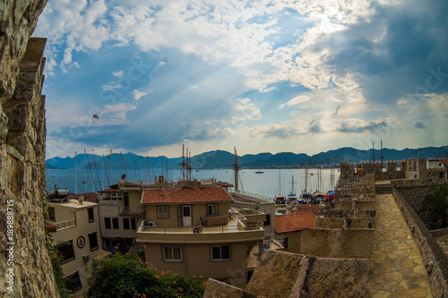 Aerial view of boats and beautiful architecture at sunset in Marmaris, Turkey. Colorful landscape with boats in marina bay, sea, city, mountains. Top view from drone of harbor with yacht and sailboat