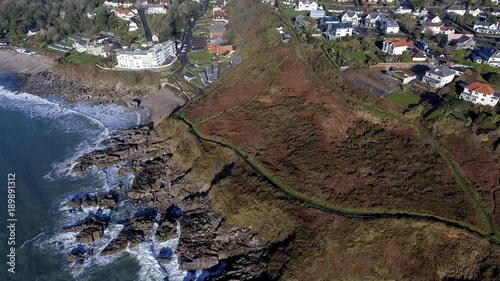 SWANSEA, UK - JANUARY 26, 2018: Ariel view of a small section of the Wales Coastal Path as it winds its way past Rotherslade Bay and Langland Bay on the Gower peninsula in Swansea, UK. photo