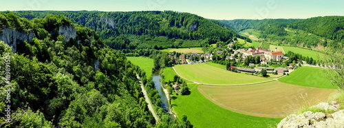 Leinwand Poster Panoramaaussicht auf oberes Donautal mit Kloster Beuron zwischen sonnigem Wald u