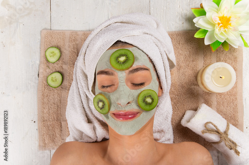 Young healthy woman with face clay mask.