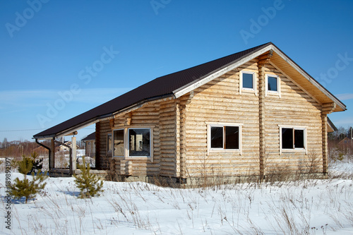 Wooden house in winter at sunny day