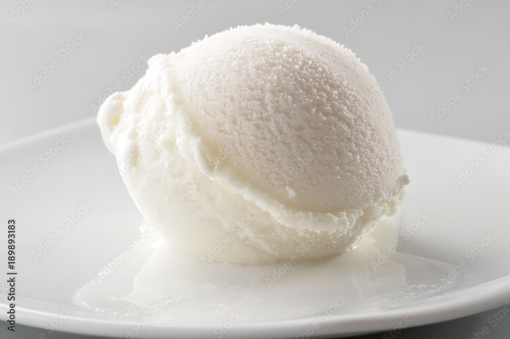 ice cream scoop on white plate close-up on gray background ice cream scoop on white plate close-up on gray background