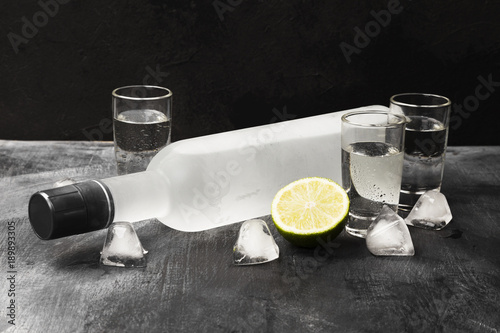 Cold vodka in shot glasses on a black background