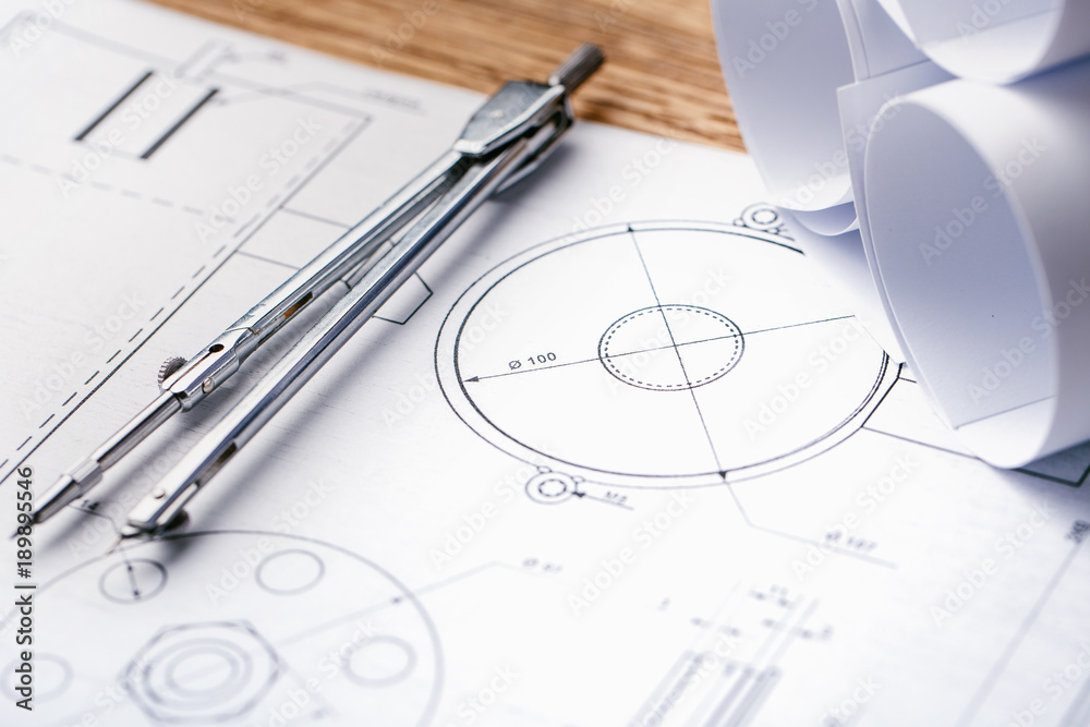 Architectural blueprints and blueprint rolls and a drawing instruments on the worktable. Drawing compass, plans. Civil Engineering, Architectural blueprints and blueprint rolls and a drawing instruments on the worktable. Drawing compass, plans. Civil Engineering,