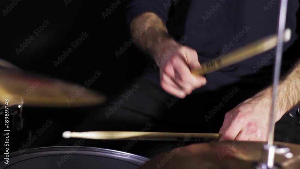 drummer play in studio on black background 
