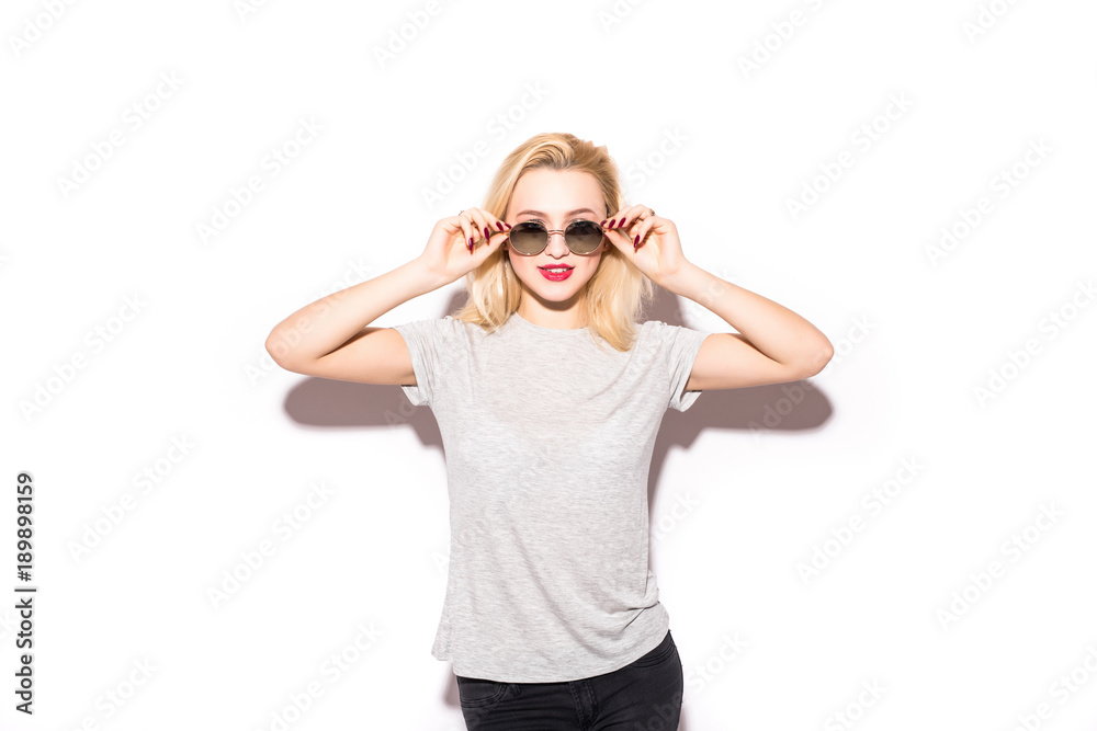 Photo of excited young blonde woman wearing sunglasses standing isolated over white background. Photo of excited young blonde woman wearing sunglasses standing isolated over white background.