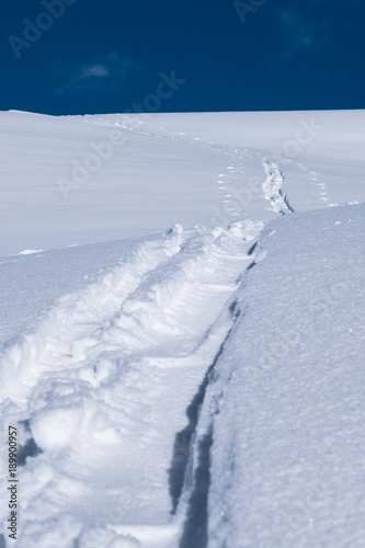 A single skier touring track imprint in new powder snow © Magnus