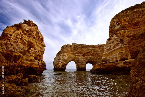 Ocean beaches of Portugal. Sand and waves on a bright summer day. City of Algarve and Faro