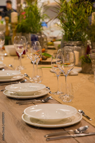 Table in the restaurant served for several persons with glasses and plates, cozy