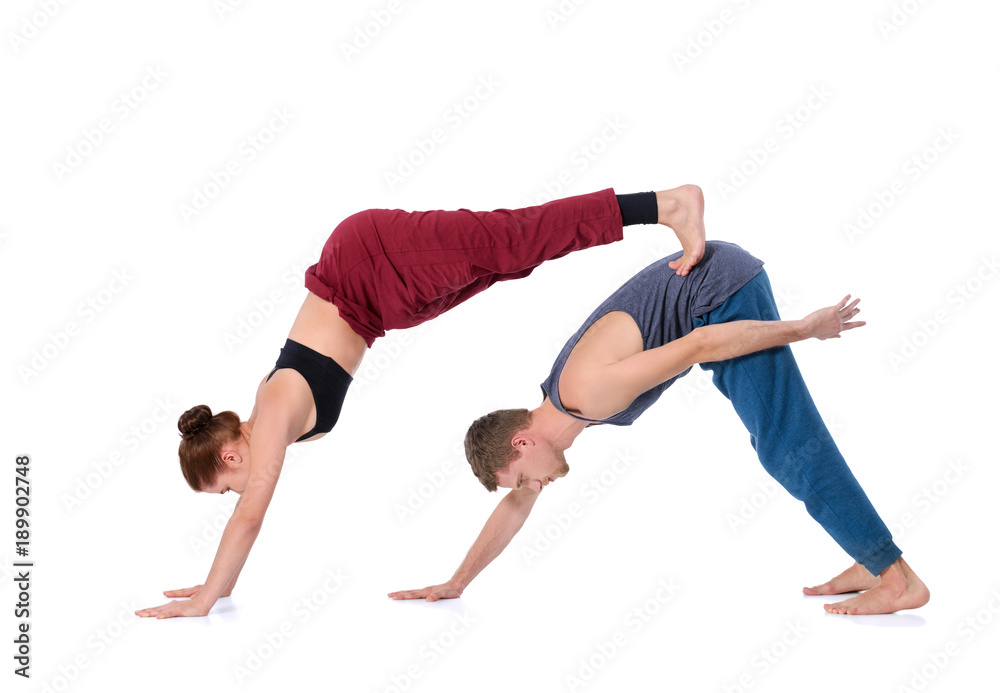 Young athletic couple practicing acroyoga. Balancing in pair Young athletic couple practicing acroyoga. Balancing in pair