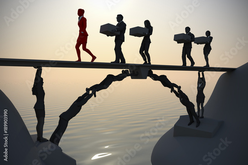 Team bridge made of people near the sea.
A bridge next to the sea made of people, where a leader and the rest of the team executives carry items from one side to the other.