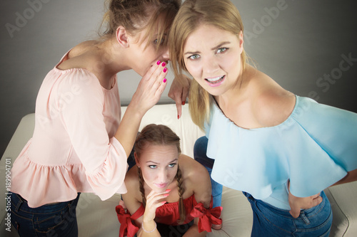Woman being gossiped by two