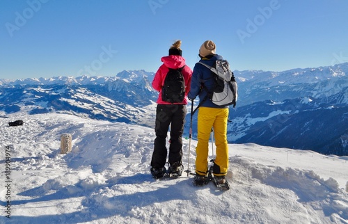 Zwei Frauen tragen Schneeschuhe im Schnee auf dem Berg Rigi / Schneeschuh Tour. Im Hintergrund verschneite Schweizer Berge