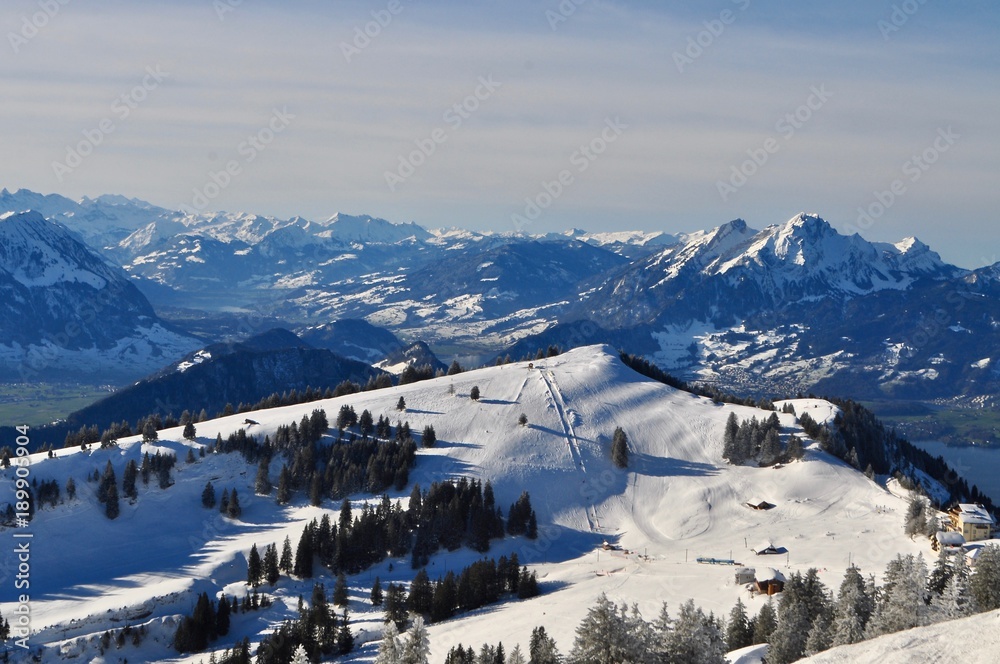 Rigi Kulm im Winter im Schnee mit Skilift und schneebedeckte Berge der Zentralschweiz im Hintergrund