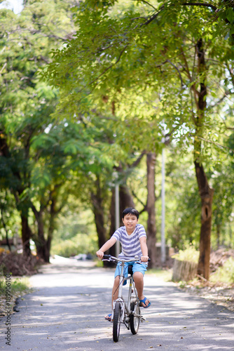 Asian boy ride bicycle in a park © TinPong