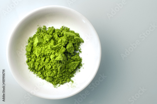 Matcha powder in white bowl. Matcha is finely ground japanese green tea leaves, this superfood has many health benefits and is packed with antioxydants, which is why it is often used in detox diets.