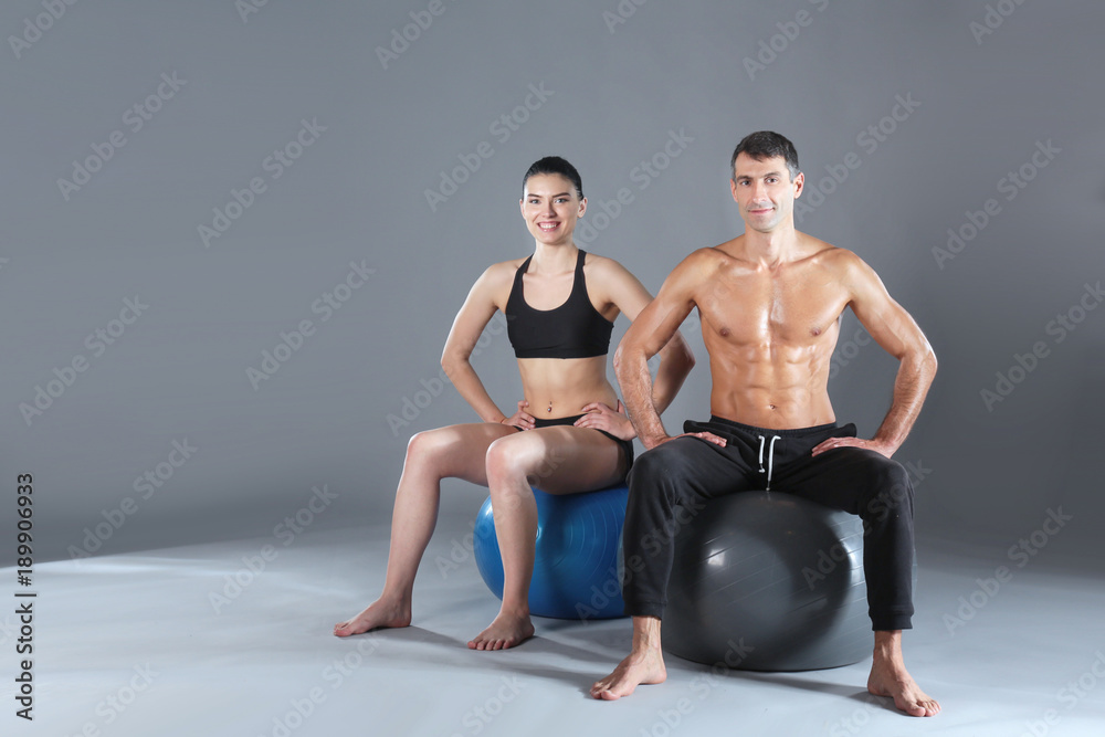 Obraz premium Two smiling people with fitness ball in the gym. Personal fitness instructor. Personal training. Gym workout.