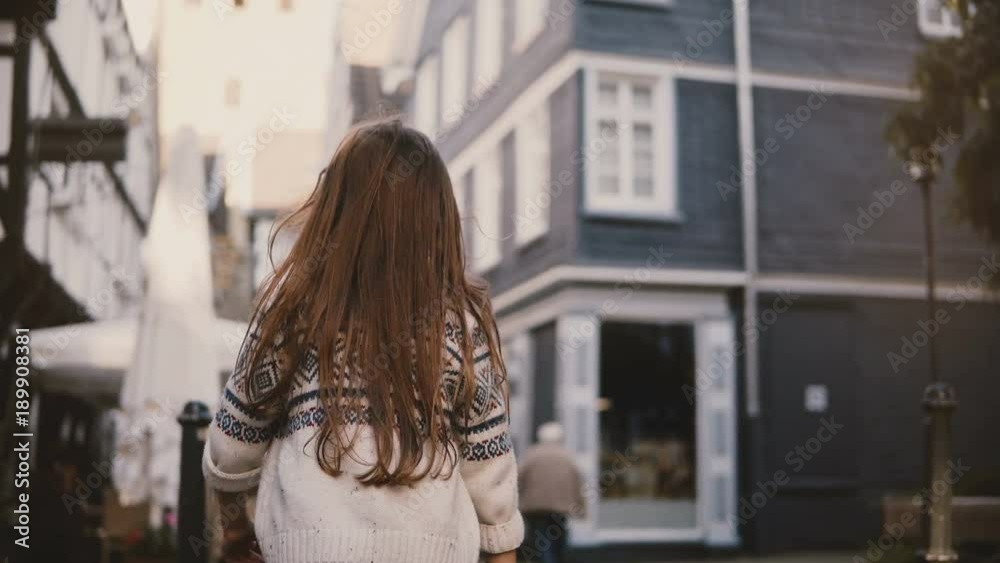 Camera follows little girl walking in old town. Back view. Female kid, long hair, wandering around ancient streets. 4K. Camera follows little girl walking in old town. Back view. Female kid, long hair, wandering around ancient streets. 4K.
