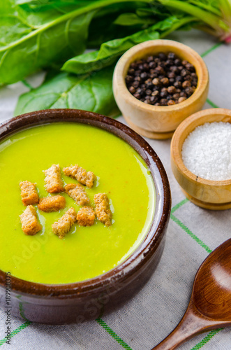 Spinach soup served on wooden board 